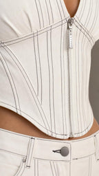 Close-up of ivory top front zipper, vertical seams, and matching pants waistband