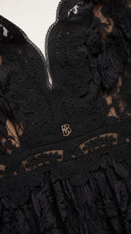 Close-up of plunging neckline and hardware detail on black dress