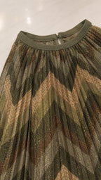 Close-up detail of green metallic chevron pleated fabric and neckline