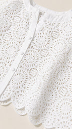 Close-up detail of white lace fabric and button closure