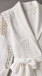 Close-up detail of white satin shawl collar and lace texture