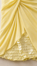 Close up detail of yellow draped fabric and circular sequin hem