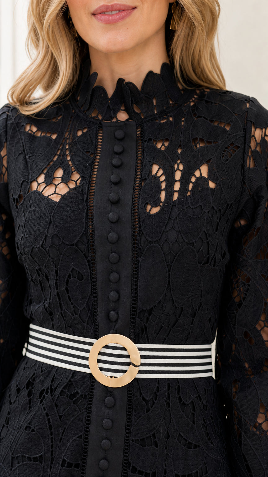 Close-up of high ruffle neck, front buttons, and belt buckle on black lace dress