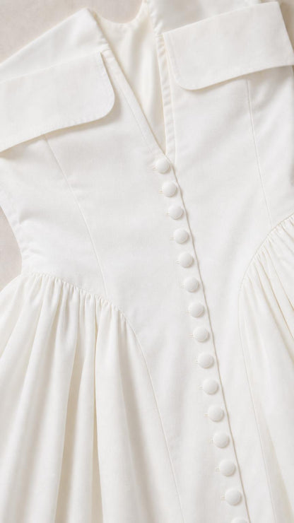 Close-up of white mini dress button and collar detail
