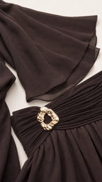 Close-up detail of the wide bell sleeves and ruched waistband with metallic buckle