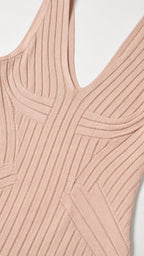 Close-up detail of V-neckline and ribbed knit pattern in blush