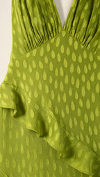 Close-up detail of green textured fabric and ruffle trim