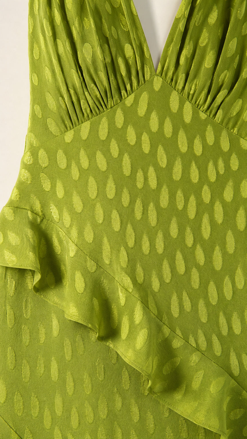 Close-up detail of green textured fabric and ruffle trim