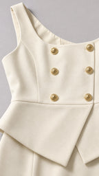 Close up of ivory vest detailing with gold buttons and peplum hem