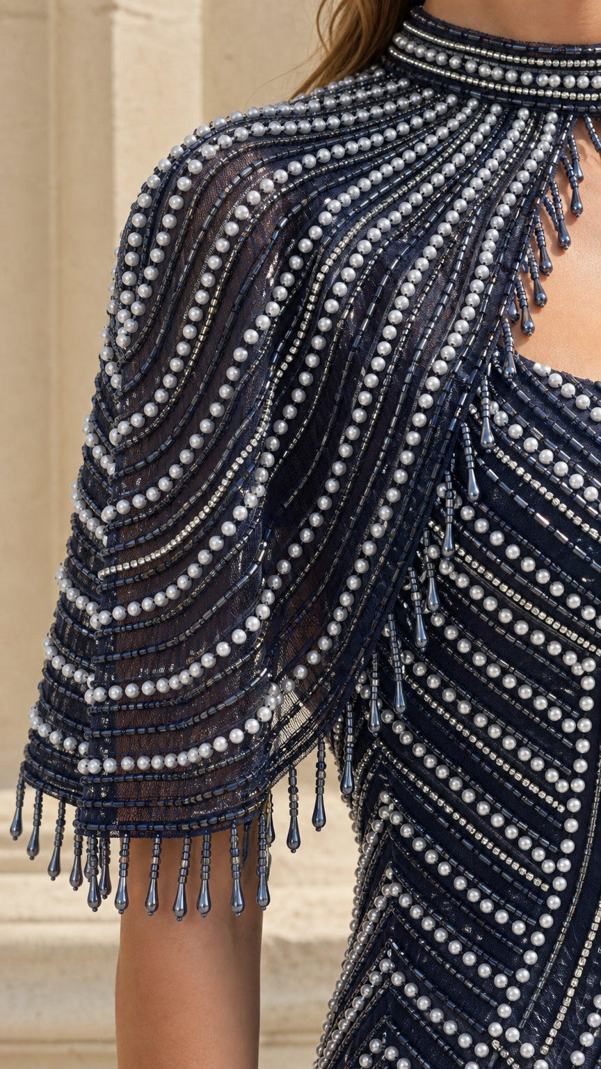 Close-up detail of beaded capelet and high neckline