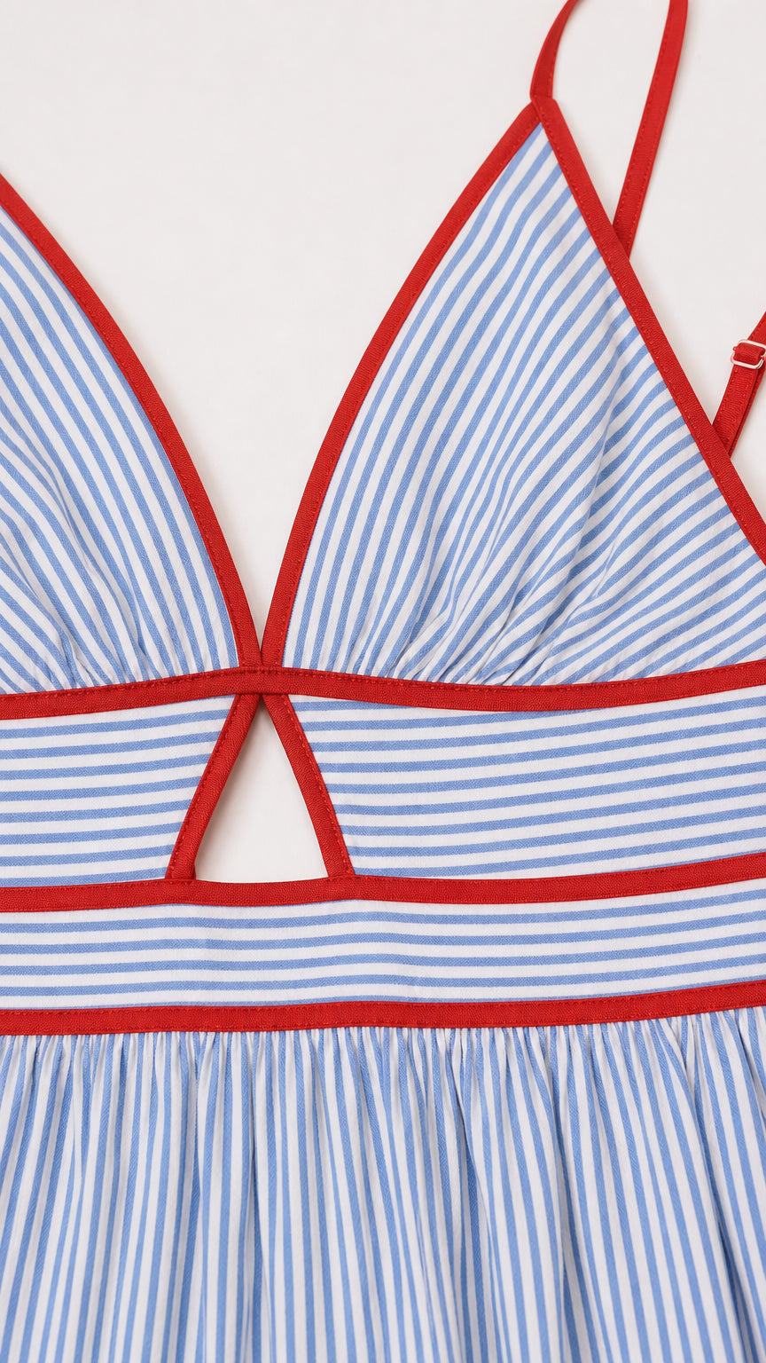 Close-up detail of red contrast trim and cutout on blue striped dress