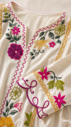 Close-up of neckline and sleeve floral embroidery and gold trim