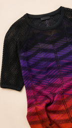Close-up flat lay showing knit texture and gradient detail of the dress