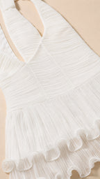 Close-up detail of white textured fabric and ruffle hem