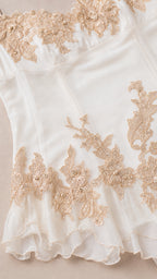 Close up of gold embroidery and sheer hem details