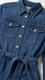 Close-up detail of denim jumpsuit collar, buttons, and chest pockets