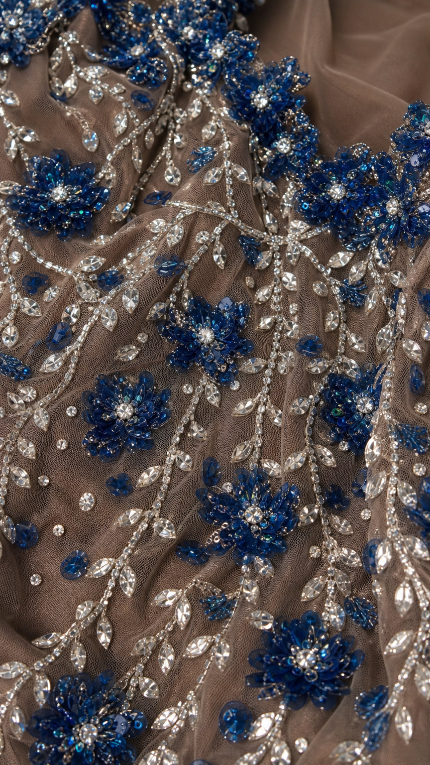 Close-up detail of blue and silver 3D floral beadwork on sheer tulle
