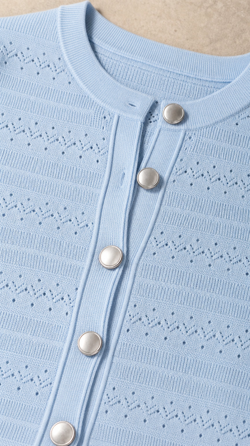 Close-up detail of knit texture and button placket on light blue dress