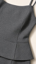 Close-up detail of textured grey houndstooth fabric and peplum hem