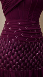 Close up of sequin and pleating detail on burgundy gown