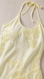 Close-up detail of floral embroidery and neckline on yellow dress