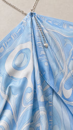 Close-up of sky blue abstract print fabric and metallic chain halter detail