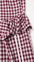 Close-up of peplum ruffle and side stripe detail on burgundy set