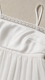 Close-up detail of white fabric and lace trim bodice