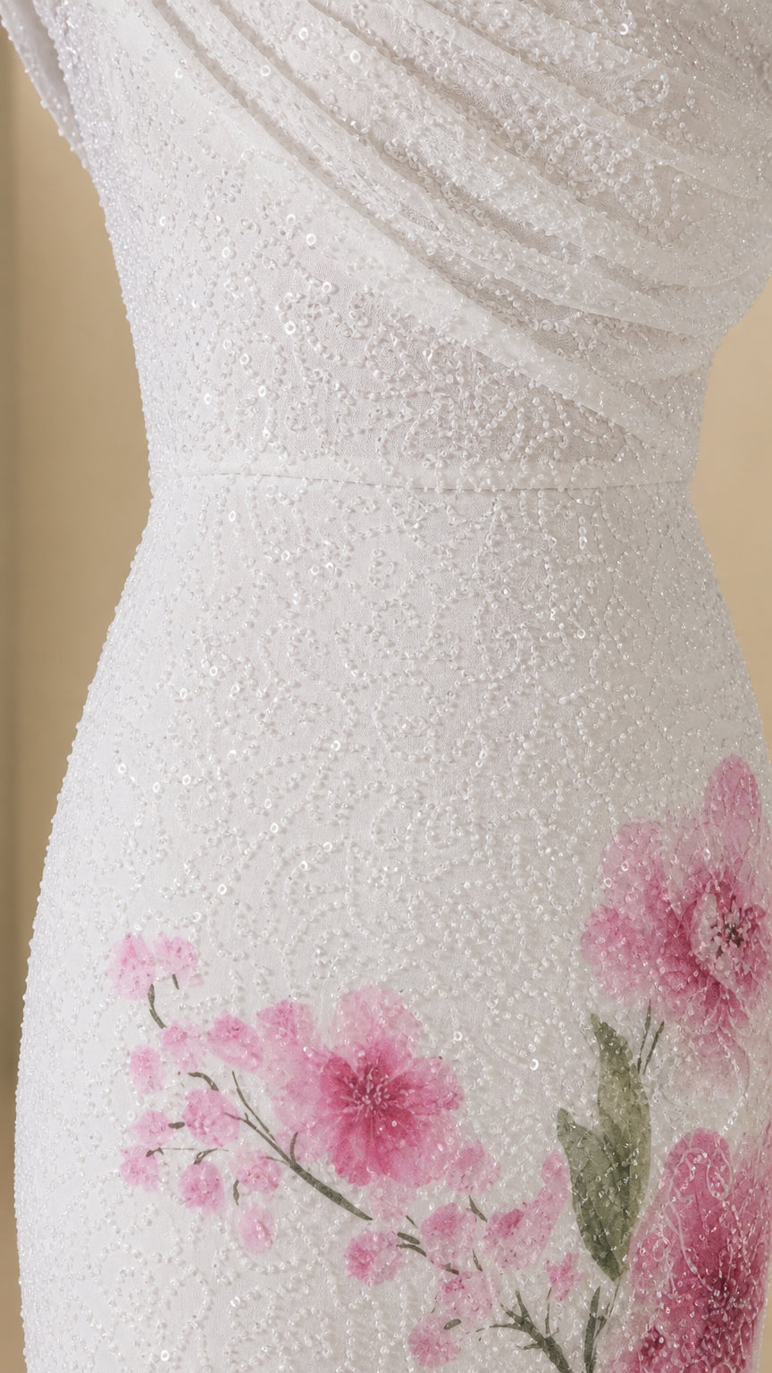 Close-up detail of draped bodice and floral hem on white gown