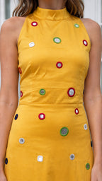 Close-up of bodice details on yellow high-neck embellished maxi dress