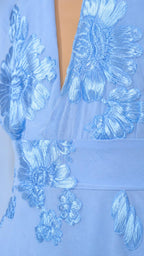 Close up detail of blue floral appliques and plunge neckline
