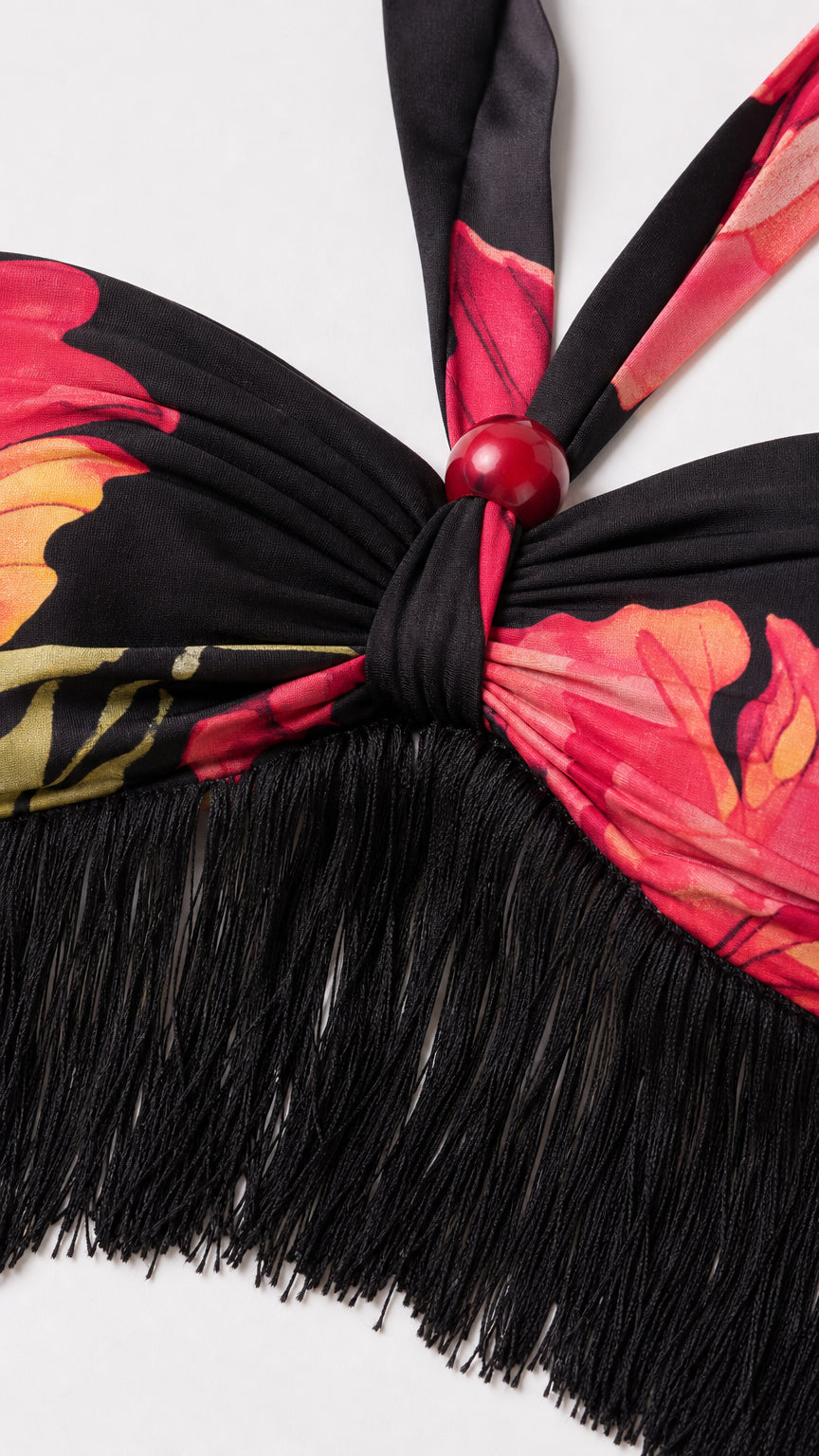 Close up detail of halter neck tie, bead accent, and fringe hem on crop top