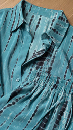 Close-up of collar, button placket, and fabric texture in teal