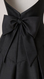 Close-up detail of the back zipper and bow on the black gown