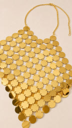 Close-up flat lay of the gold metallic disc halter top