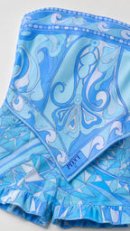 Close-up detail of the blue geometric scarf pattern and ruffle hem