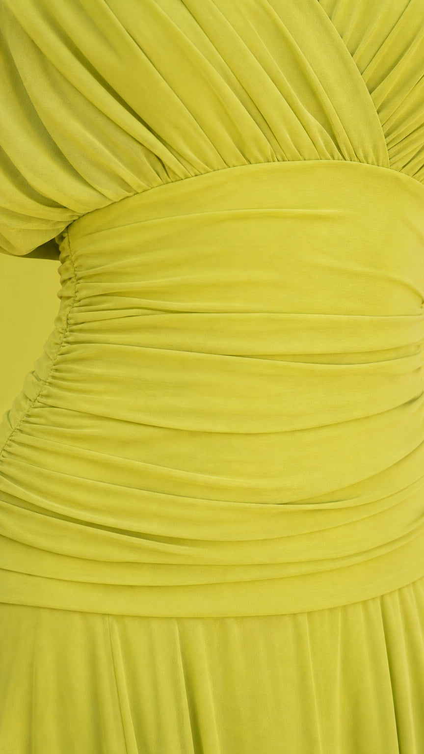 Close-up detail of the ruched bodice and pleated skirt in lime