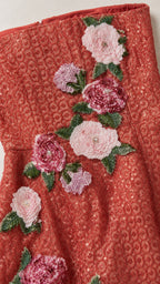 Close-up of red sequin fabric and pink floral appliques
