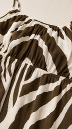 Close-up detail of smocked bodice on brown zebra print dress
