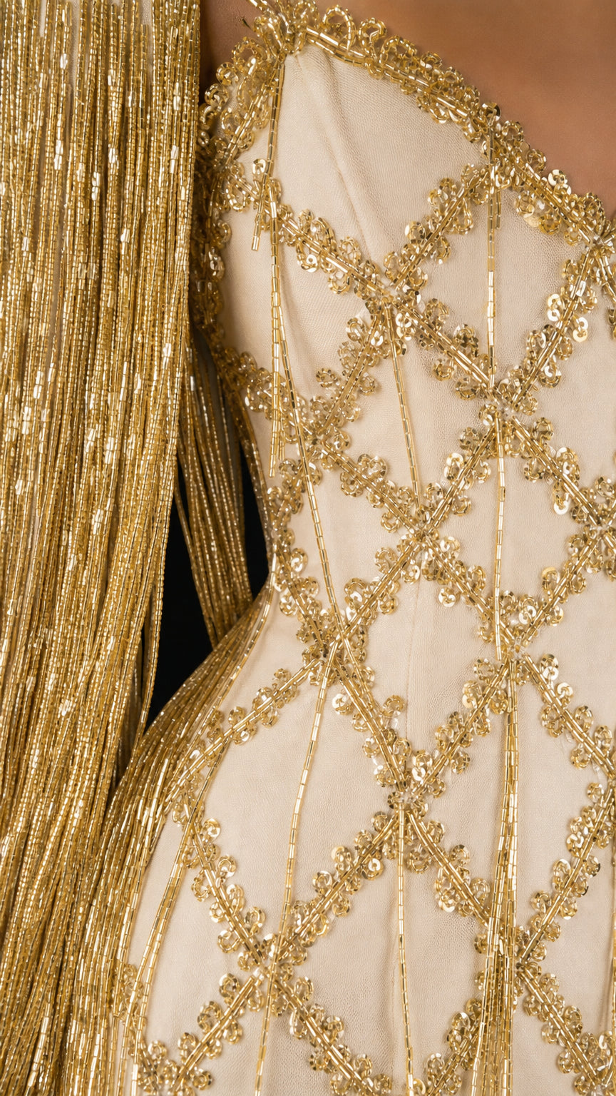 Close-up detail of gold lattice beadwork and fringe sleeves