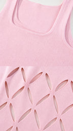 Close-up detail of square neckline and hem cutouts on pink dress