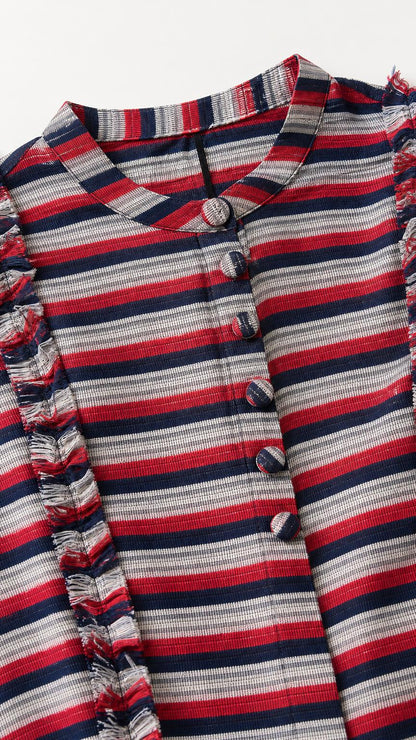 Close-up of fabric, buttons, and ruffle trim details