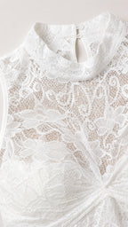 Close-up detail of white lace fabric and halter neckline
