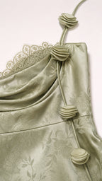Close-up of rosette strap and lace detail on sage green dress