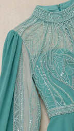 Close-up of bodice embroidery and high mock neckline in teal