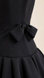 Close-up of back bow and pleated waist detail on black gown