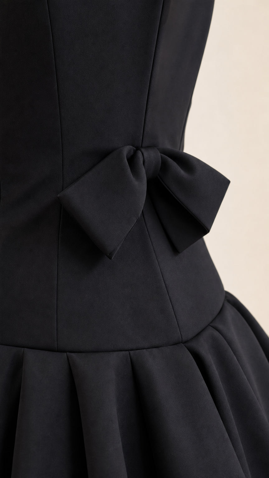 Close-up of back bow and pleated waist detail on black gown