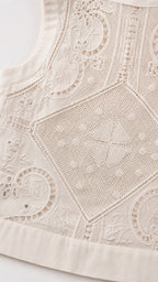 Close-up detail of white embroidered fabric pattern