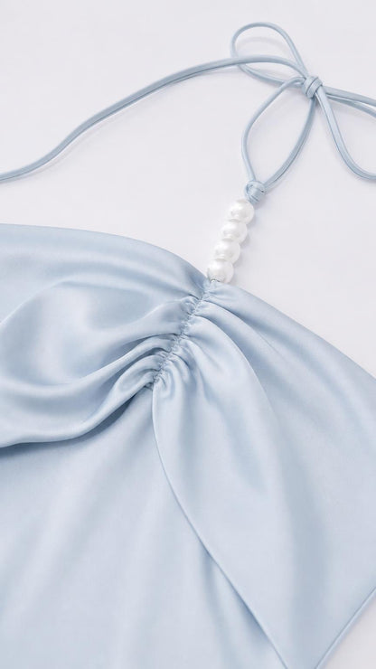 Close-up of halter strap with faux pearl embellishments and ruched bodice