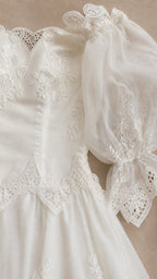 Close-up detail of bodice and puff sleeves on white dress